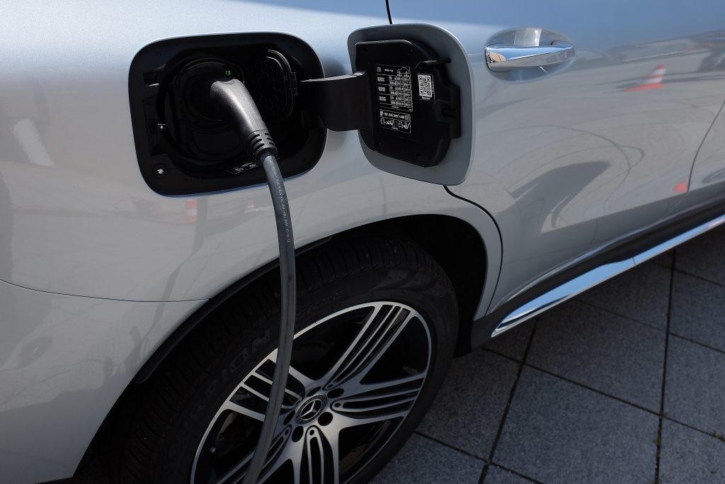A close up of the charger port on a silver Mercedes EV
