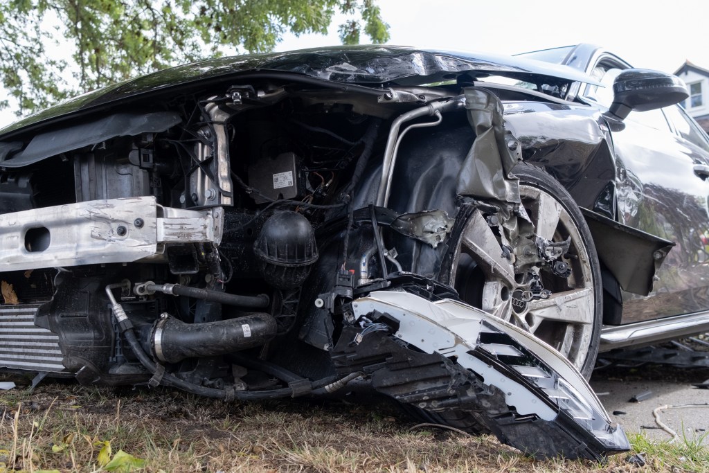 A wrecked Audi with the front bumper missing