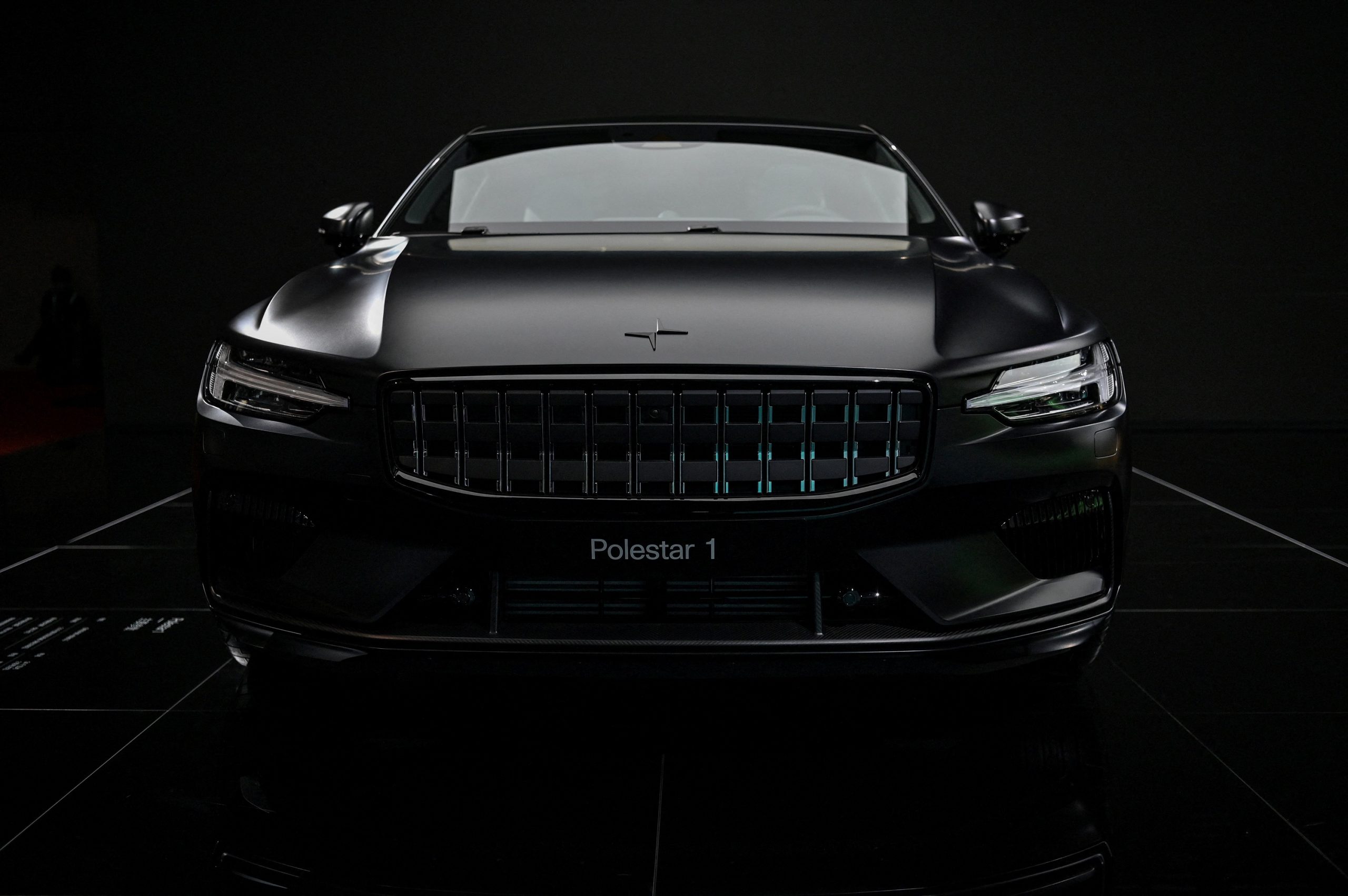 A black Polestar 1 seen in a dark photo booth shot from the front