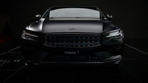 A black Polestar 1 seen in a dark photo booth shot from the front