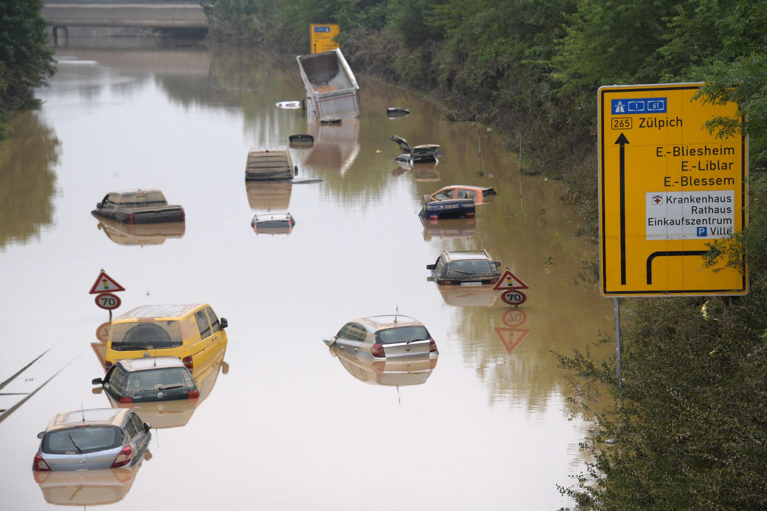 Cars wade through a flooded street in Germany