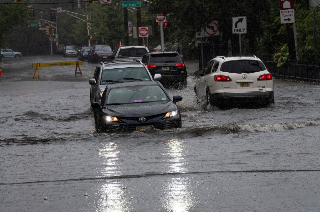 Cars navigate their way through a flooded street in New Jersey