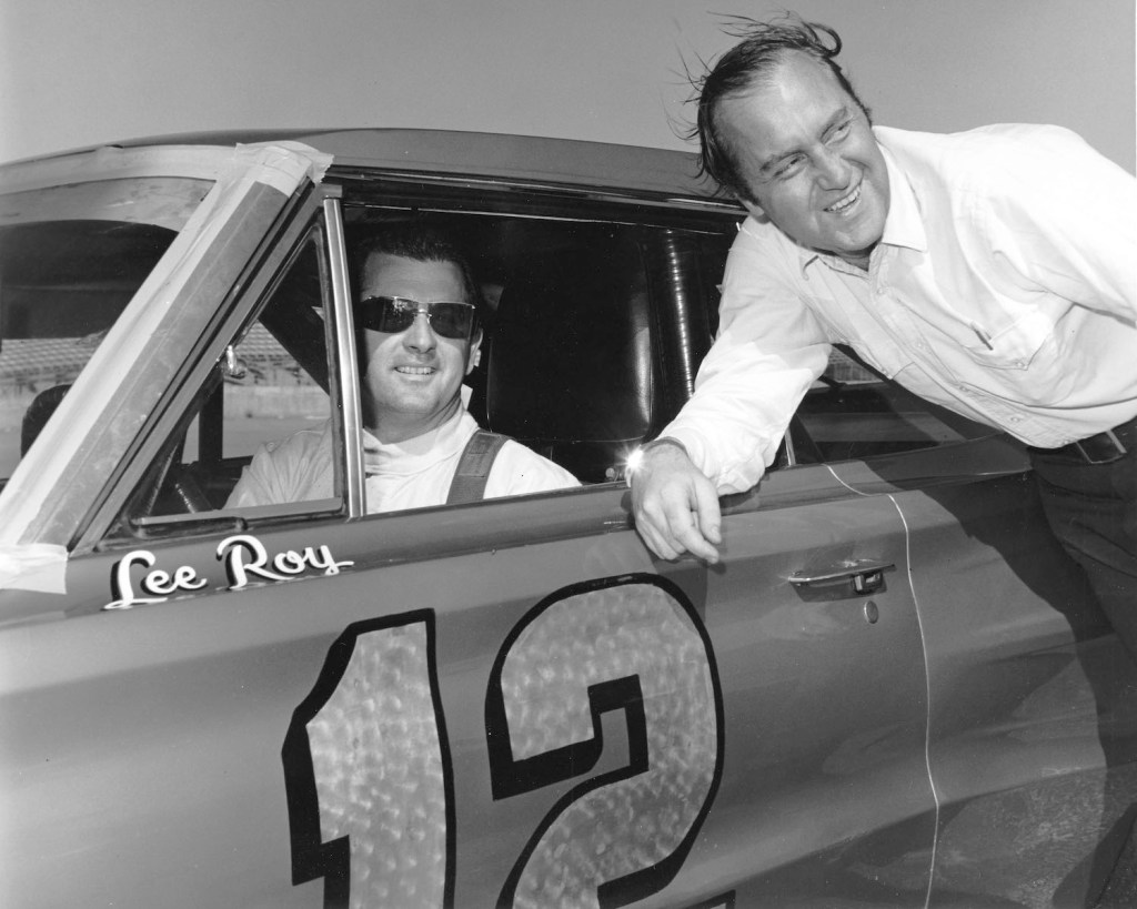 DAYTONA BEACH, FL — February 1966: Motorsports journalist Brock Yates (R) with driver LeeRoy Yarbrough on pit road at Daytona International Speedway. Yarbrough drove Jon Thorne’s Dodge Charger to an eighth place finish in the Daytona 500 NASCAR Cup race. (Photo by ISC Images & Archives via Getty Images) How Did the Cannonball Run Record Start?