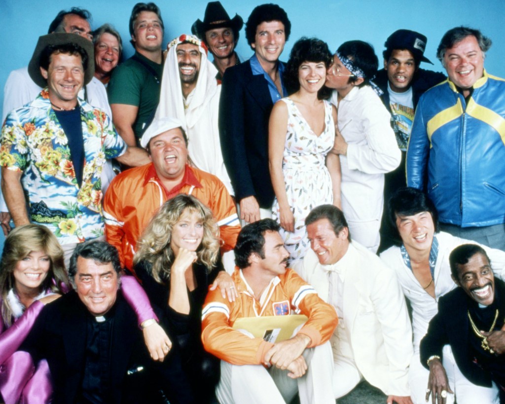 The cast of 'The Cannonball Run', directed by Hal Needham, 1981. Back row, left to right: Alfie Wise, Jack Elam (hidden), unknown, Joe Klecko, Jamie Farr, Mel Tillis, Bert Convy, Adrienne Barbeau, Michael Hui, Rick Aviles, and Warren Berlinger. Centre (in orange) Dom DeLuise. Front row, left to right: Tara Buckman, Dean Martin, Farrah Fawcett, Burt Reynolds, Roger Moore, Jackie Chan and Sammy Davis, Jr. (Photo by Silver Screen Collection/Getty Images) How Did the Cannonball Run Record Start?