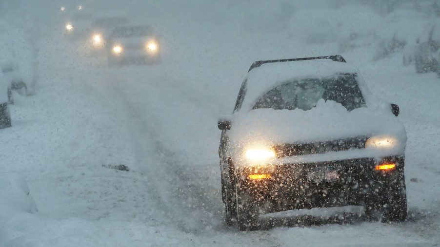 A car wades cautiously through a viscous blizzard in New York