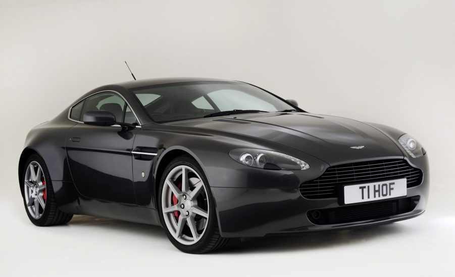 A black Aston Martin V8 Vantage shot from the front 3/4 angle in a studio booth