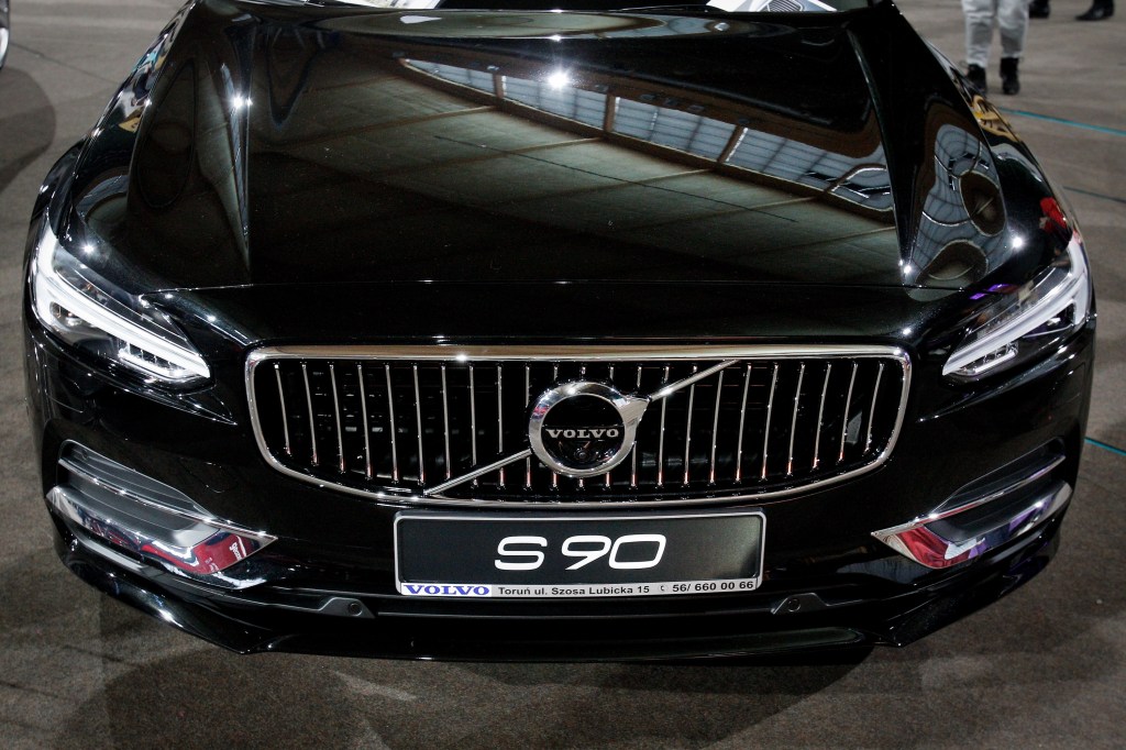 A black Volvo S90 shot from the hood down at an auto show