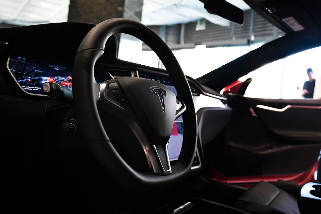 The interior of a standard Tesla Model S, complete with a regular old circular wheel.