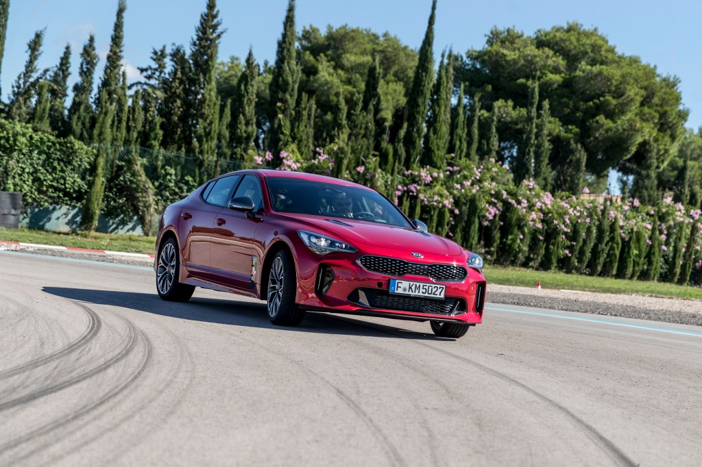 The Kia Stinger luxury car on a race track, shot from the low front 3/4 angle