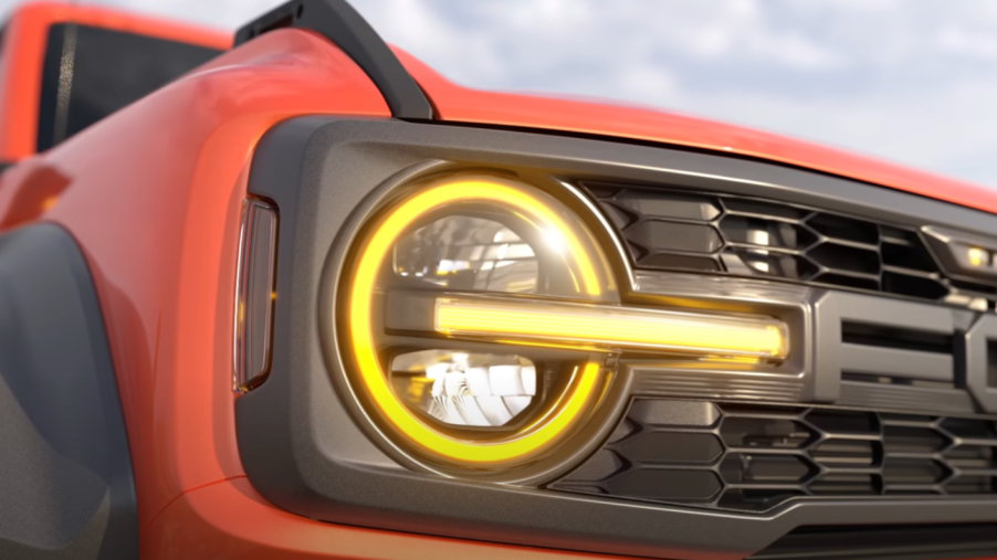 Grille and headlight on orange Ford Bronco Raptor