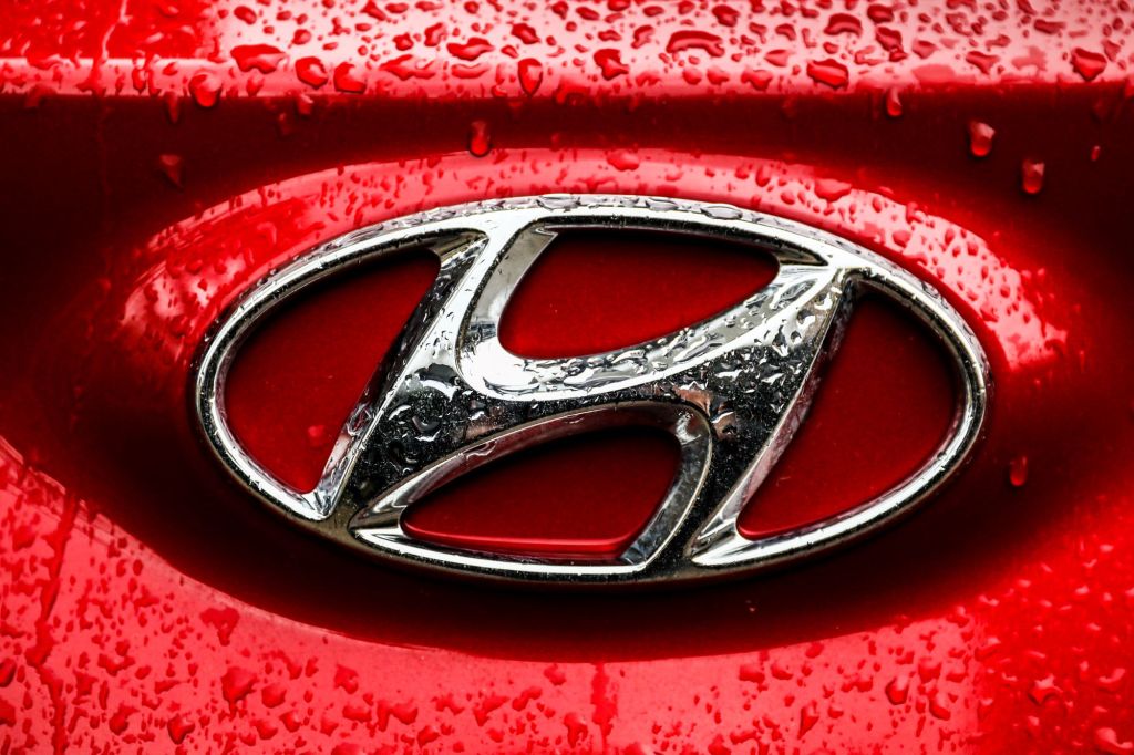 A chrome Hyundai logo on a red vehicle.