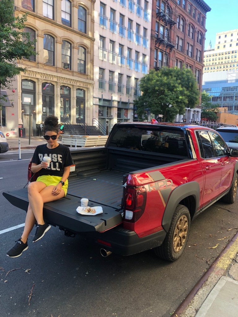 Brandy Bajalia sitting on the tailgate of a 2021 Honda Ridgeline HPD in NYC
