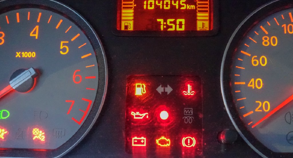 A vehicle's instrument cluster has different symbols lit up. 