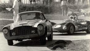 Vintage Jaguar XK140 barn find in a vintage photo racing a Ferrari