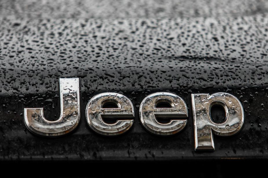 Chrome Jeep logo, maker of the Jeep Grand Cherokee Trackhawk, on a black car with rain drops.