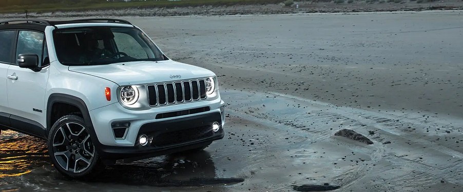 A white 2021 Jeep Renegade parked on the beach.