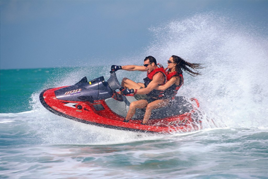 A young couple rides a Kawasaki Jet Ski personal watercraft near Islamorada in the Florida Keys
