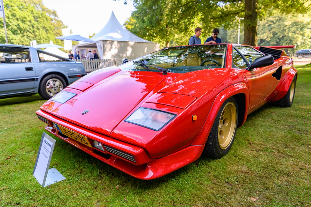Red Lamborghini Countach seen from a low front angle parked at a car show in the Netherlands. This Countach is similar to the one used in the drag race featured in this article.