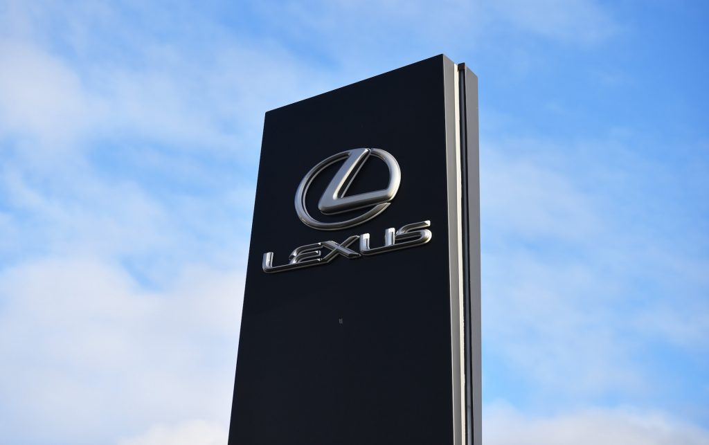 The Lexus logo on a car dealership sign