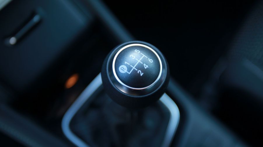 A six-speed manual transmission shifter gear select inside a vehicle with black interior