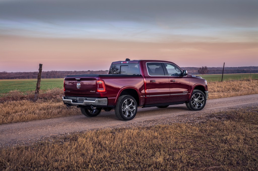 Maroon 2022 Ram 1500 driving by a field, is the new Backcountry Edition better than the GMC Sierra 1500 AT4X?