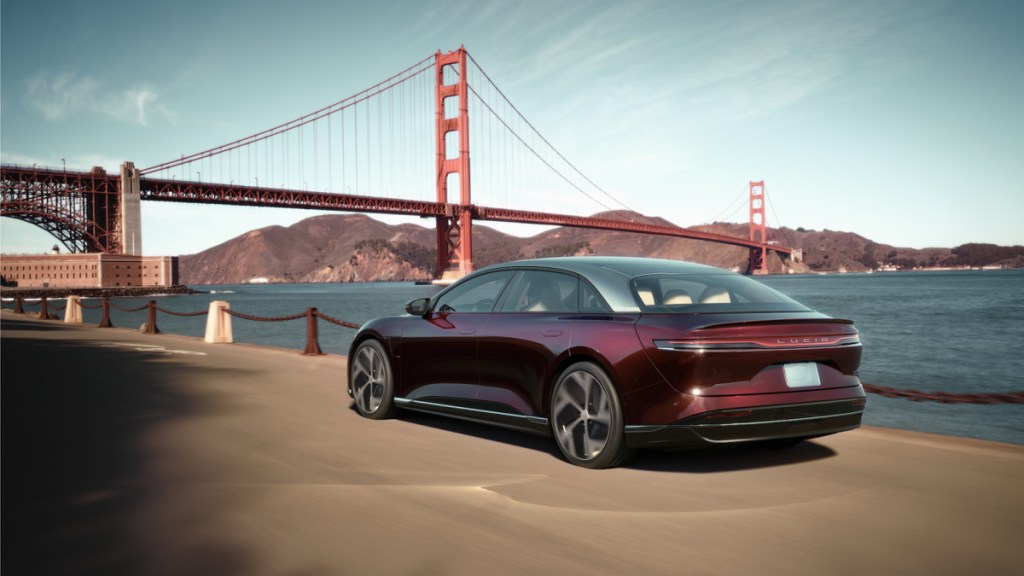 Maroon Lucid Air parked in front of the Golden Gate Bridge
