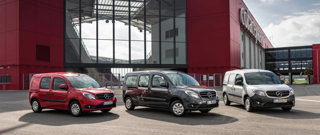 A trio of Mercedes-Benz Citan vans parked outside of a large building