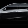 A dark gray 2021 Tesla Model Y against a black background.