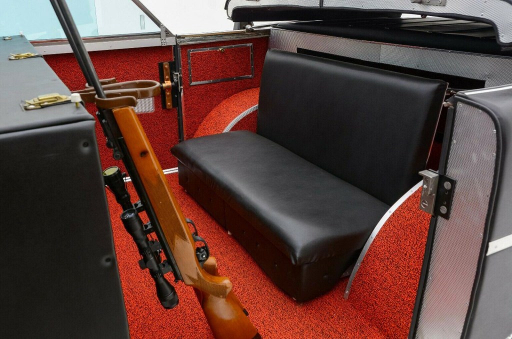 a hunting rifle set in its holder inth back seat of the Mohs Sarafikar