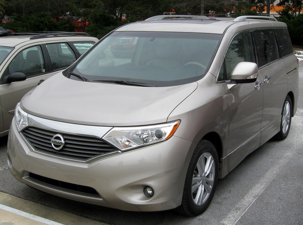 a gold 2011 nissan quest parked in a parking lot during the day