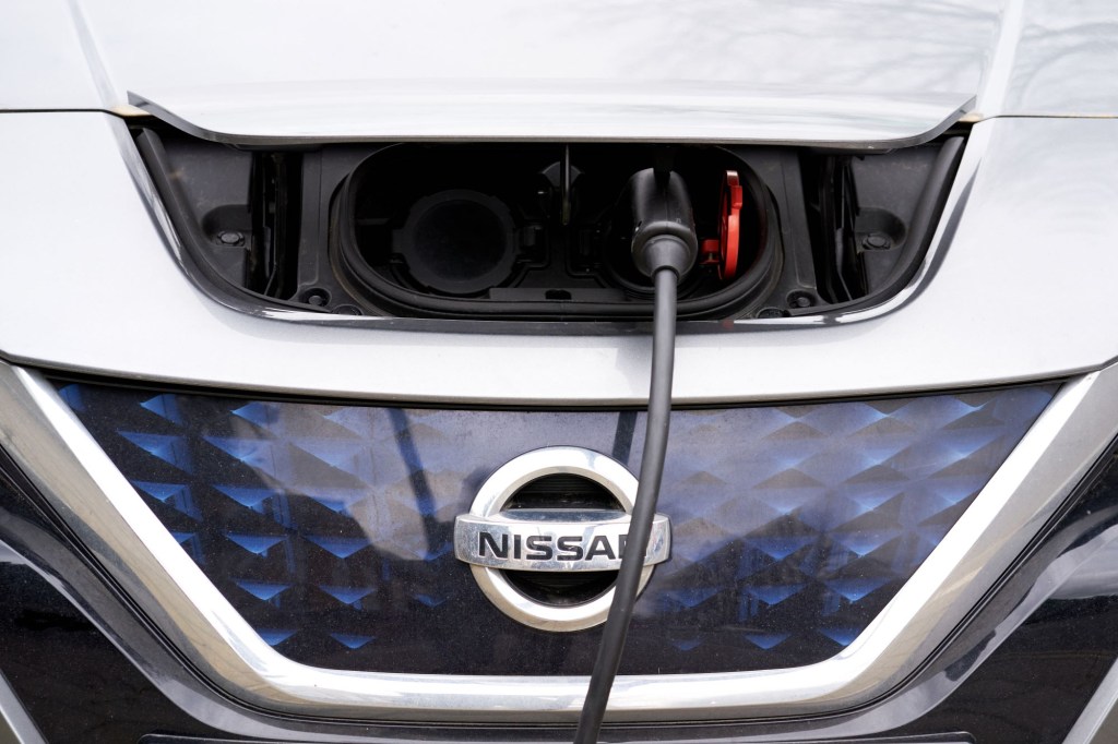 A white Nissan Leaf hood while charging.