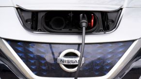 A white Nissan Leaf hood while charging.