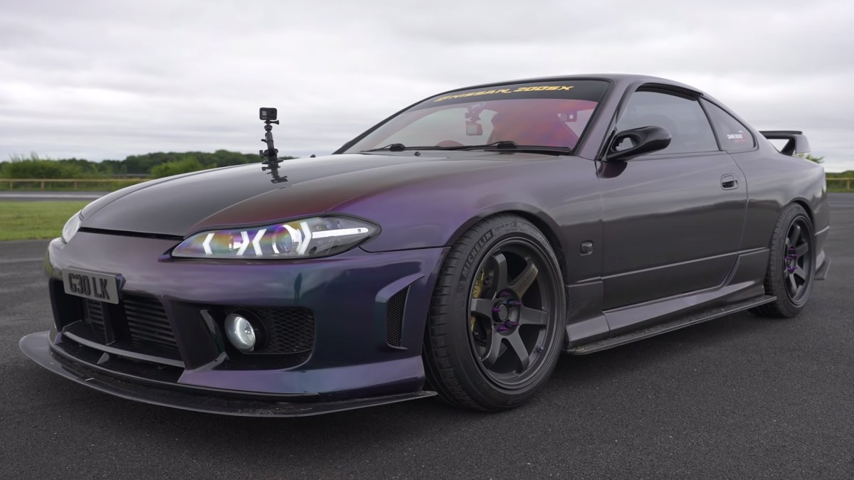 A purple Nissan Silvia S15 with a body kit lining up for a drag race