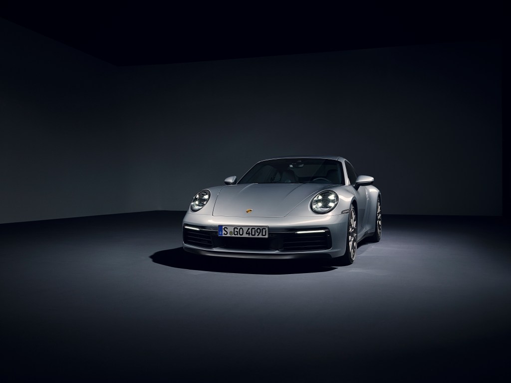 A silver Porsche 911 Carrera in a photo studio