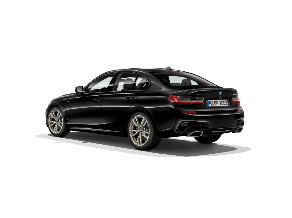 A black BMW M340i Xdrive shot against a white background from the rear 3/4 angle