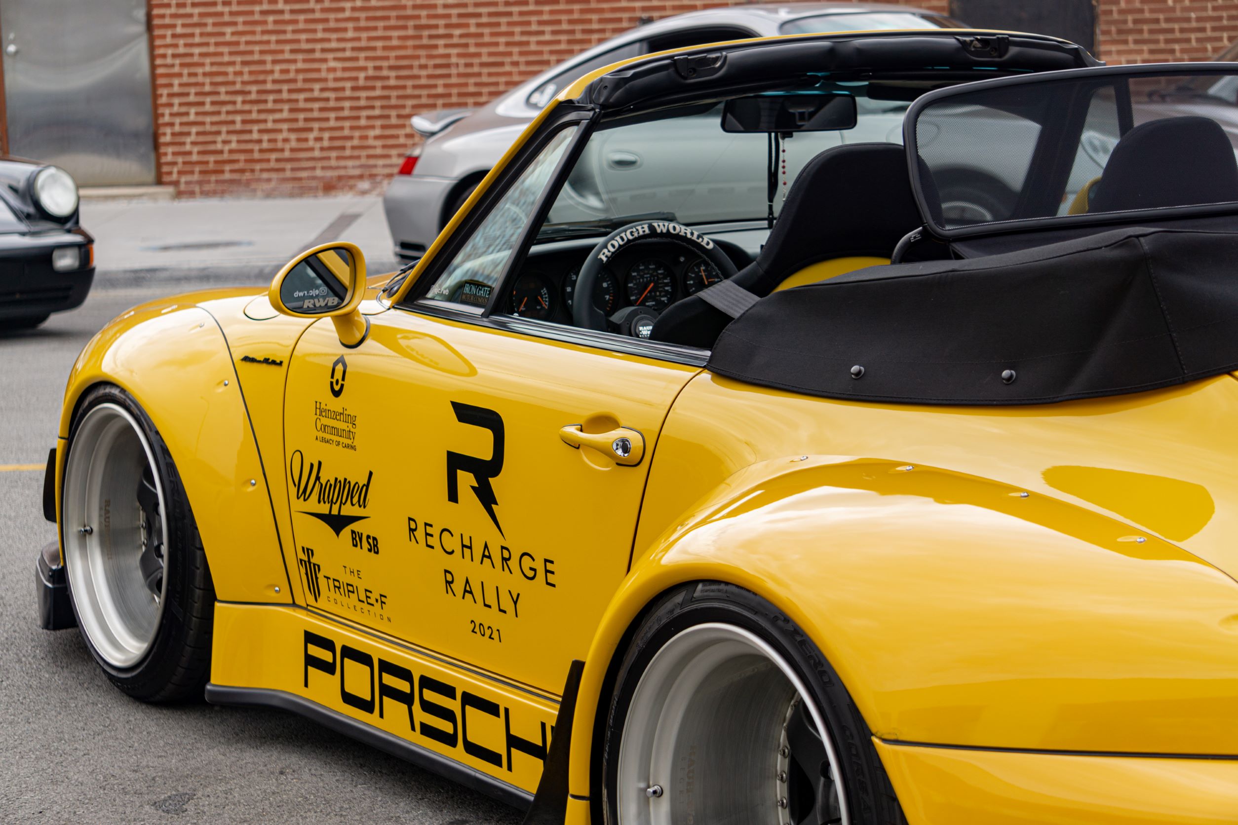 The rear 3/4 close-up view of the yellow-and-black RWB Porsche 993 911 Cabriolet 'Nohra'