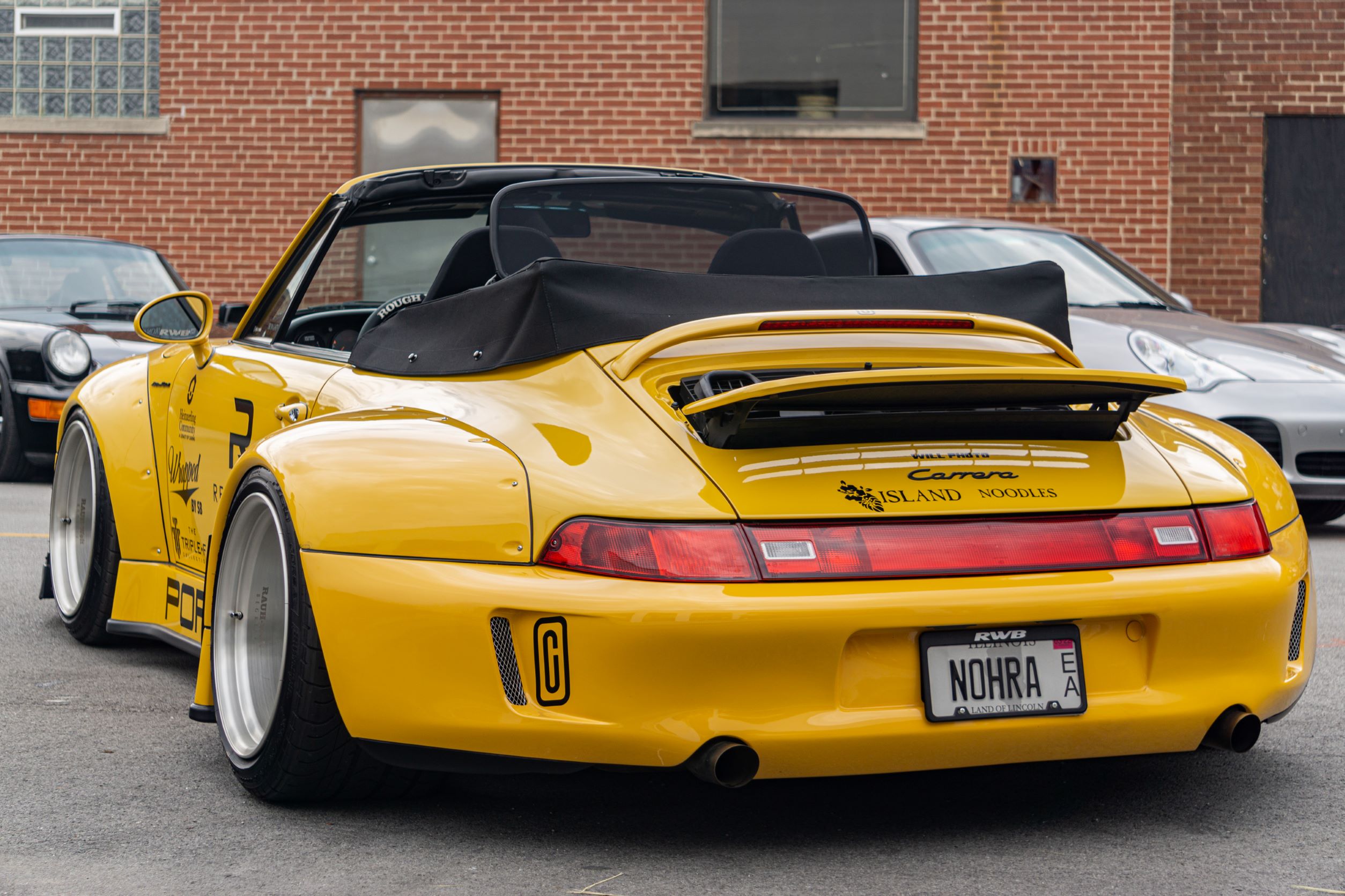 The rear view of the yellow-and-black RWB Porsche 993 911 Cabriolet 'Nohra'