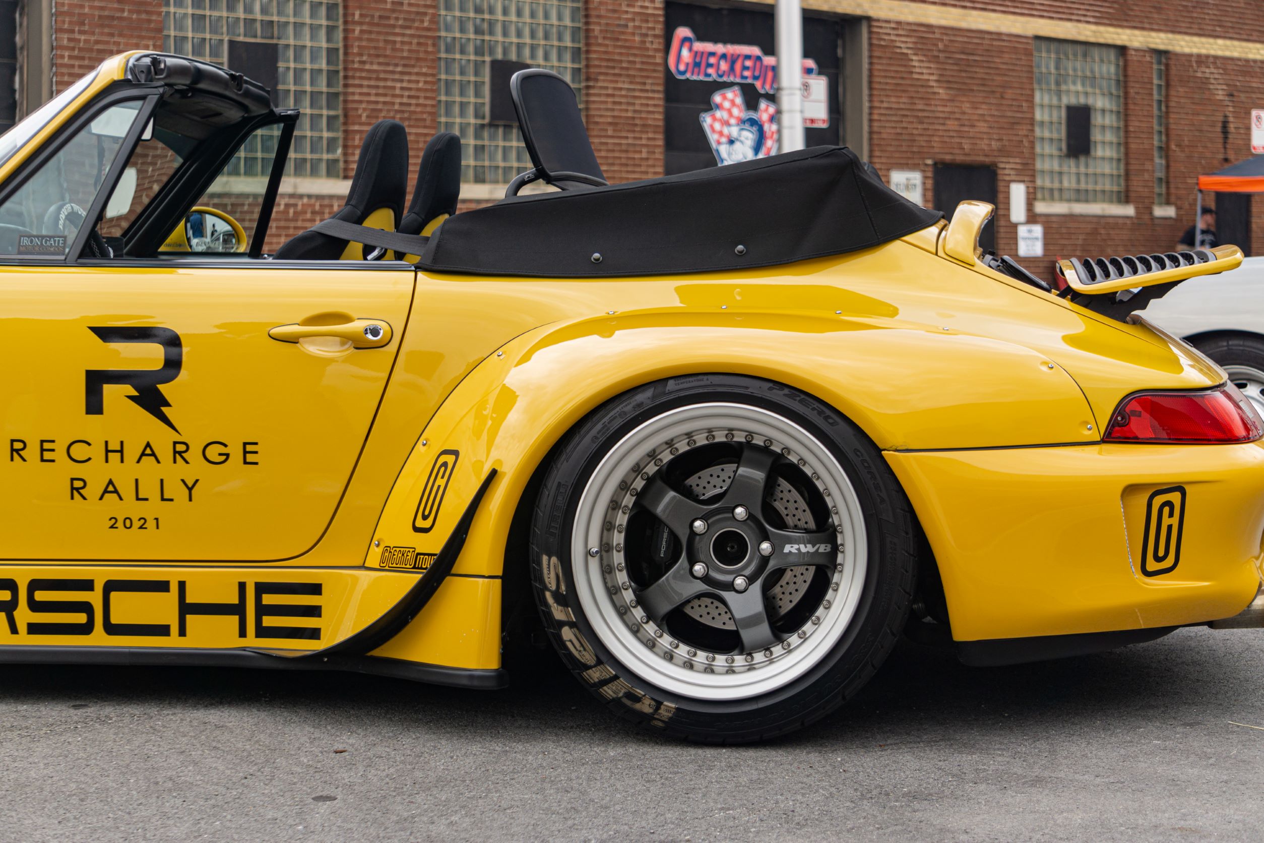 The rear wheel and fenders of the yellow-and-black RWB Porsche 993 911 Cabriolet 'Nohra'