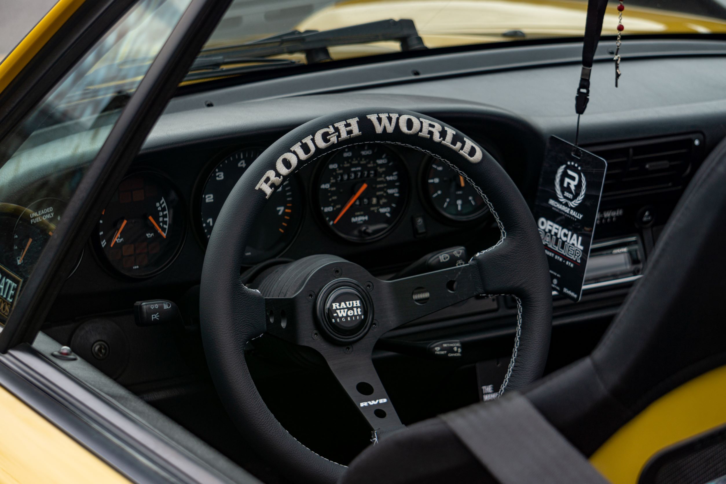 The black steering wheel, gauges, and seat of the yellow-and-black RWB Porsche 993 911 Cabriolet 'Nohra'