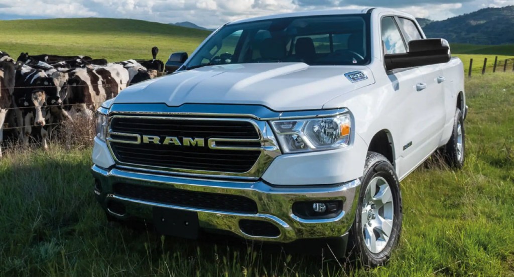 A white Ram 1500 Big Horn pickup truck is parked in the grass. 