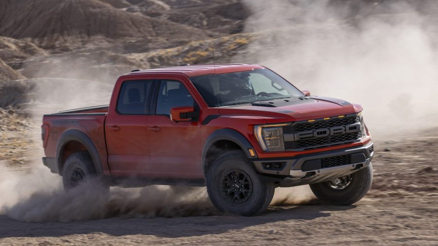 Red 2021 Ford F-150 Raptor driving on mountainous terrain
