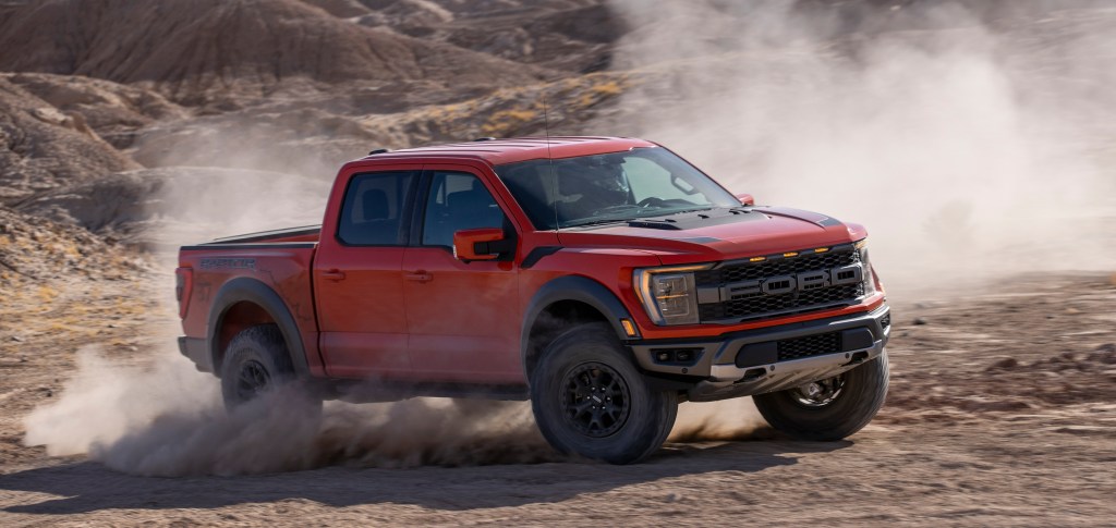 Red 2021 Ford F-150 Raptor driving on mountainous terrain