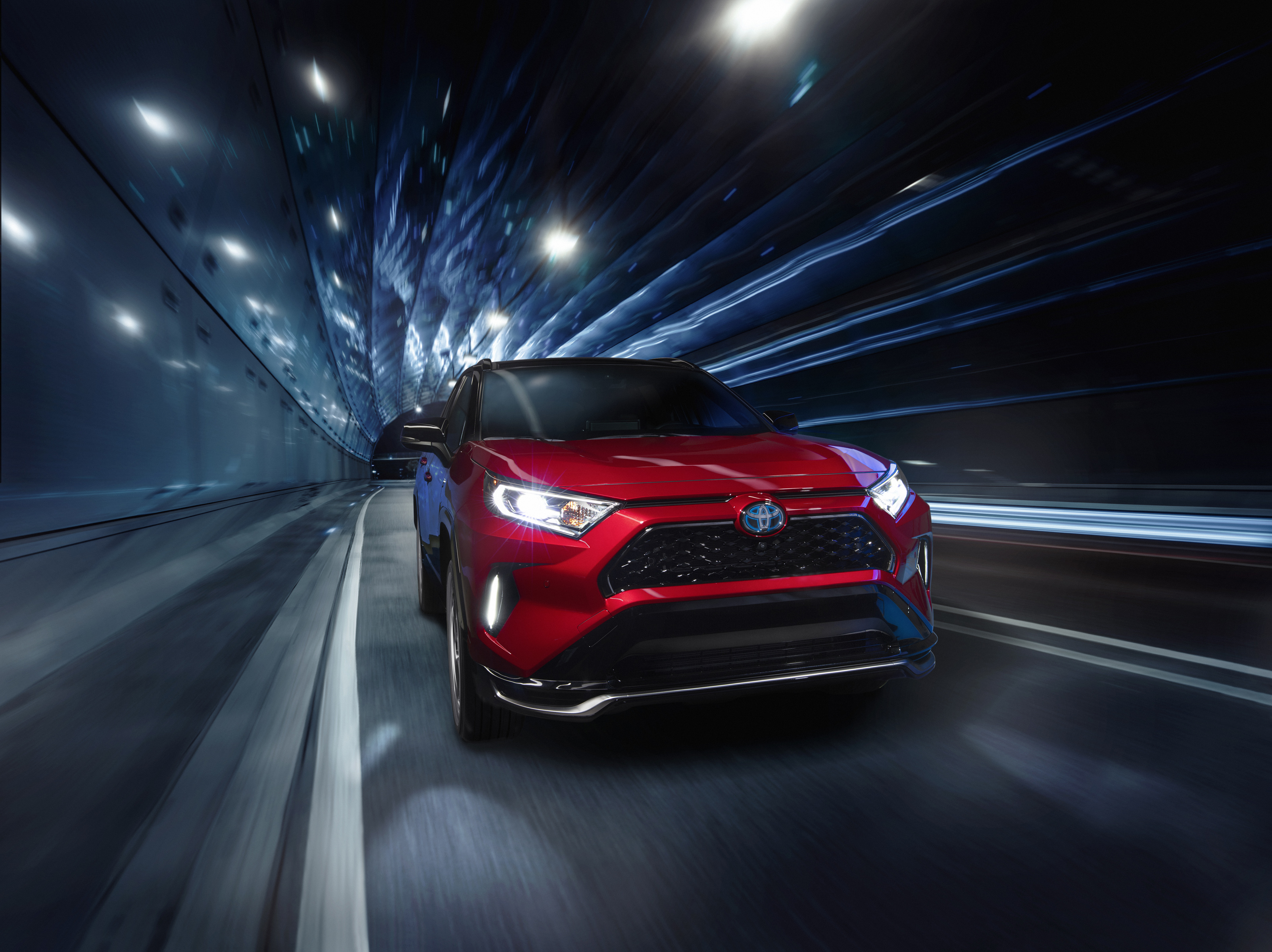 Red 2021 Toyota RAV4 Prime driving through a tunnel