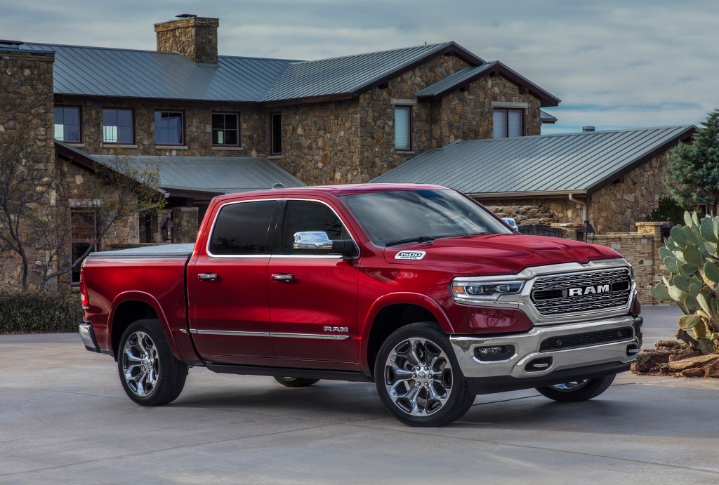 Red 2022 Ram 1500 parked in front of a large house