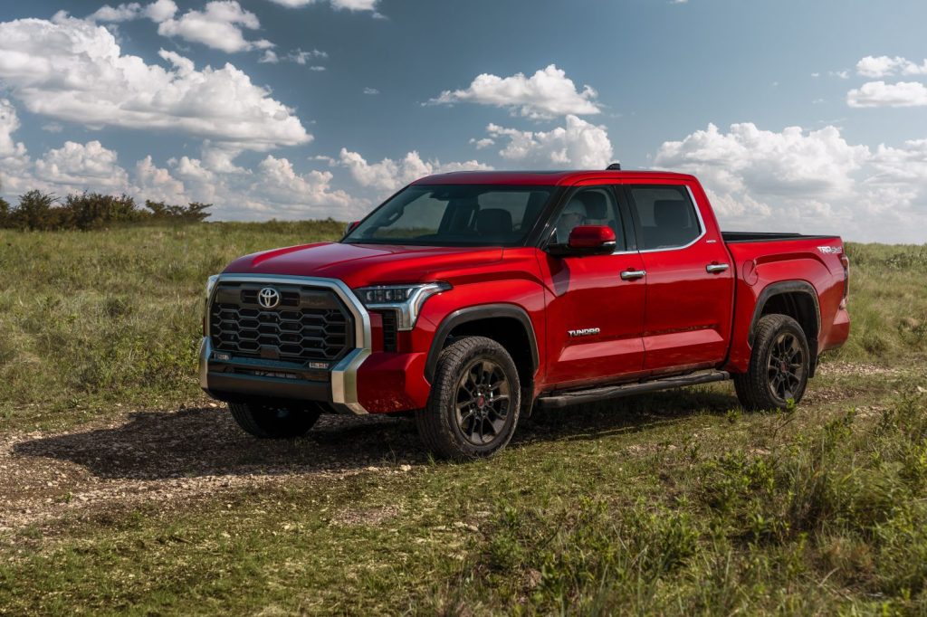 Red 2022 Toyota Tundra parked in a grassy field