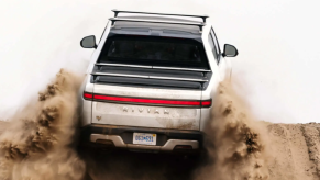 The Rivian R1T electric truck model driving on sand dunes