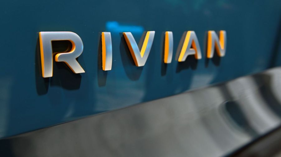 A silver Rivian logo on a blue vehicle.