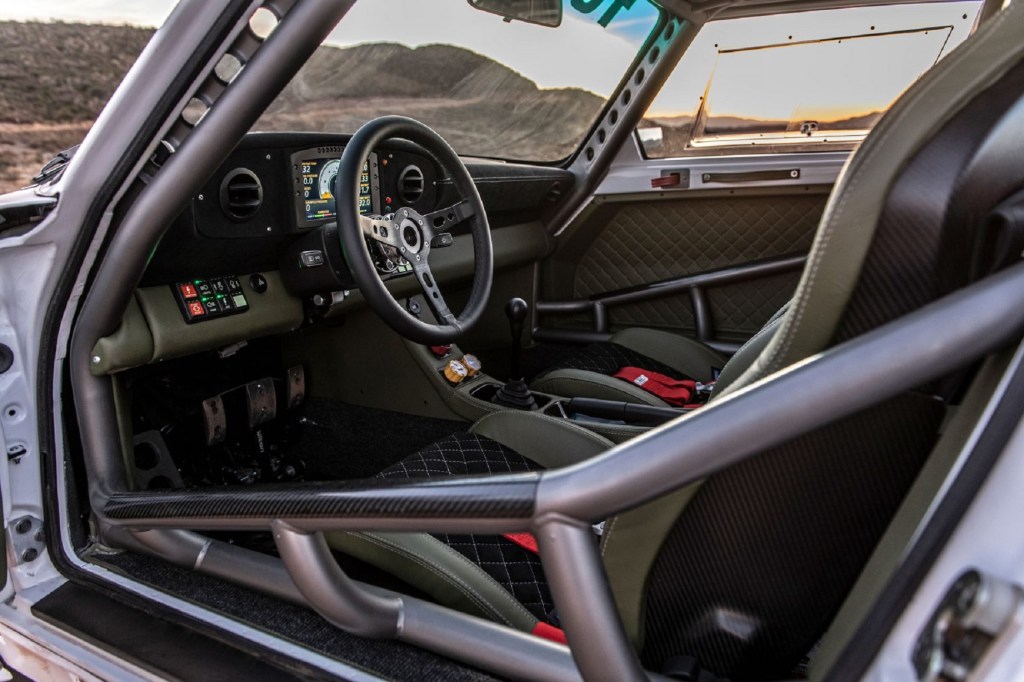 The black-and-green interior with steel roll cage of a Russell Built Fabrications Baja 911