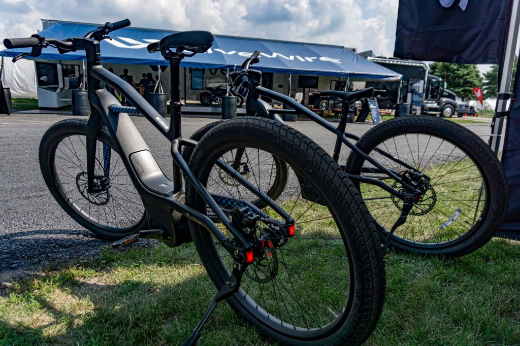 The rear 3/4 view of two black Serial 1 MOSH/CTY ebikes under a tent