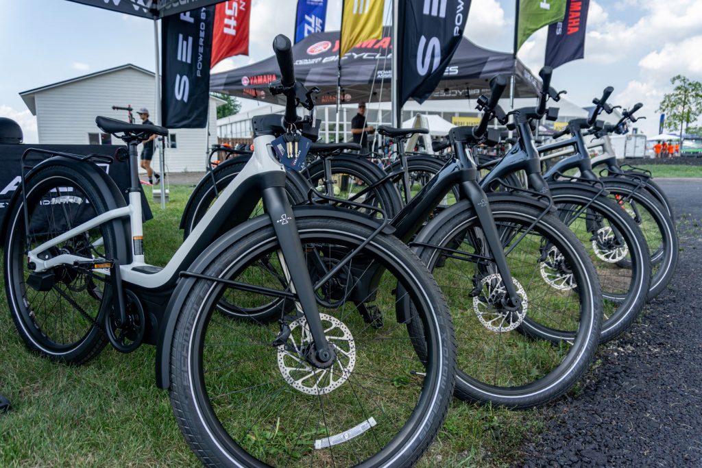 A line of white and black Serial 1 ebikes under a tent